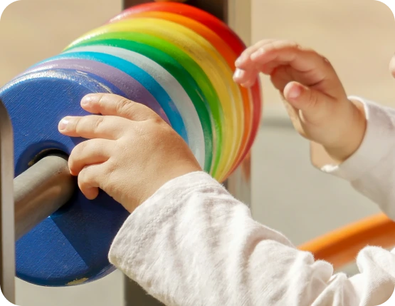 Bebê explora um brinquedo de peças coloridas.