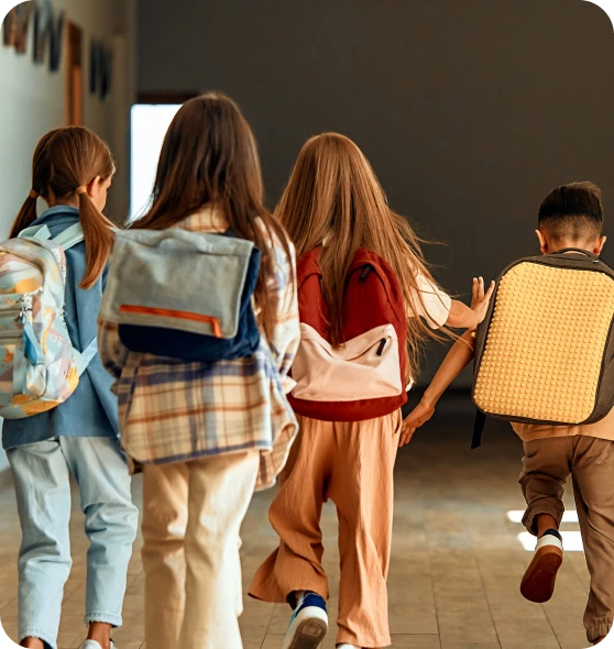 Alunos caminham juntos pelo corredor da escola.